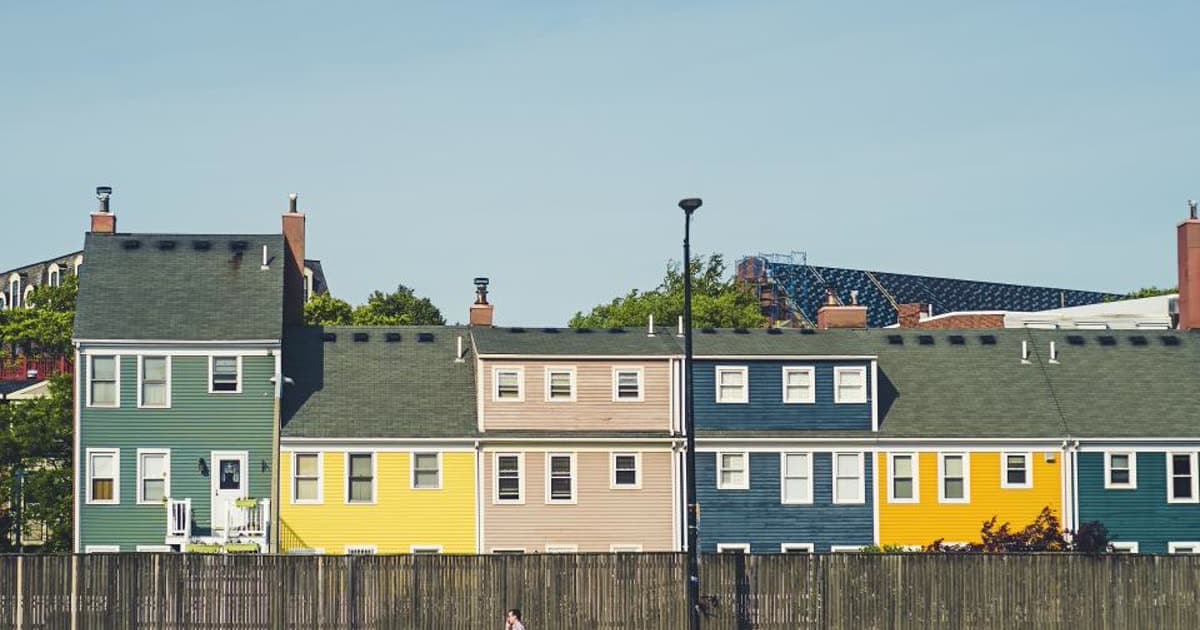 A row of colourful suburban houses under a clear sky
