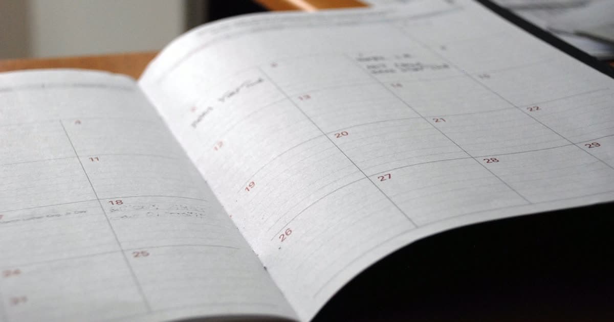 An open paper calendar with handwritten notes