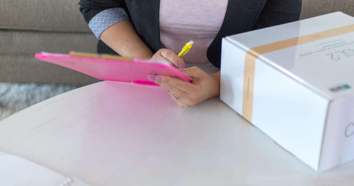 Someone filling in a form on a clipboard at a desk