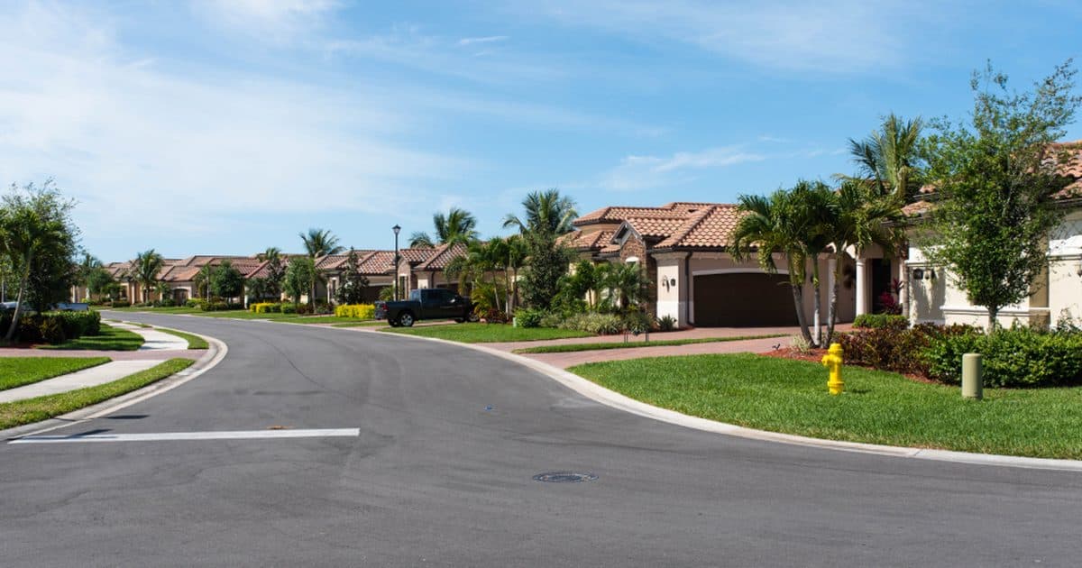 A quiet suburban street with houses and lawns