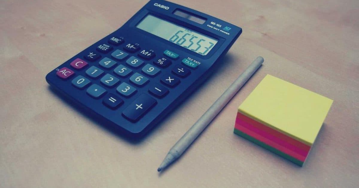 A calculator, pencil and sticky notes on a table