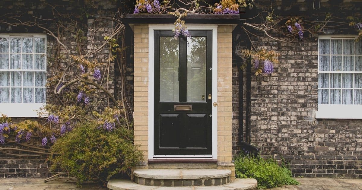 The front door of a brick house with flowers